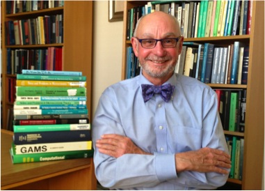 David A. Kendrick in his office, with his books and a copy of the GAMS volume visible